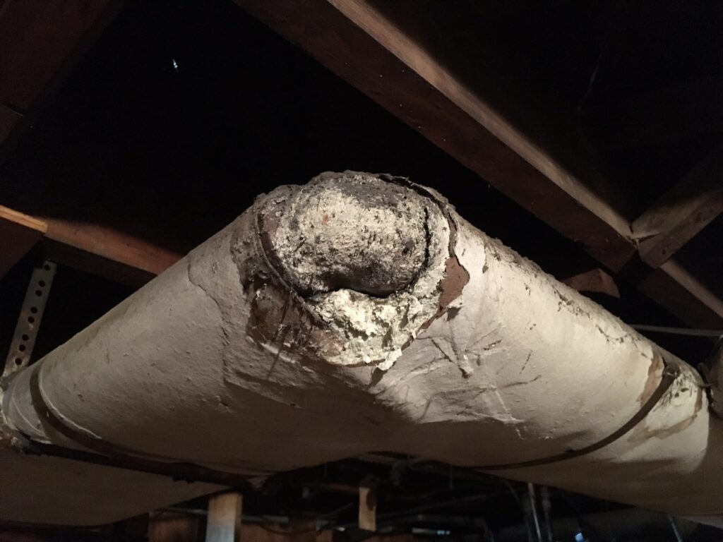 Asbestos paste on elbow of pipe wrap.