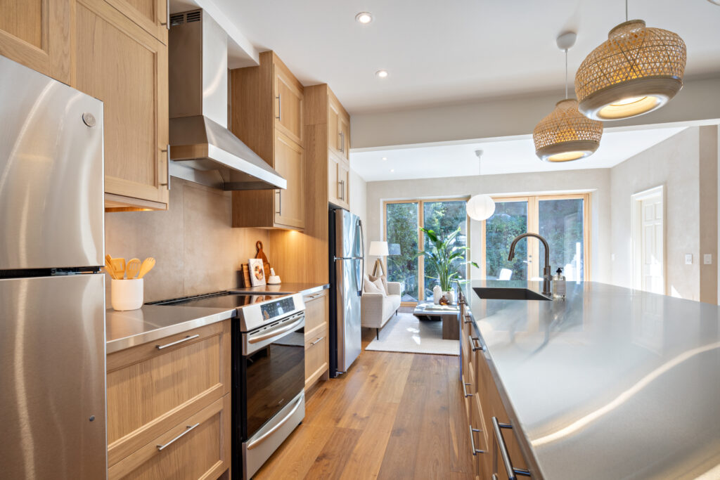 The multigenerational home's shared floor includes the kitchen and living room. The kitchen countertop is 95 percent recycled steel. Photo Credit: Craig A. Williams